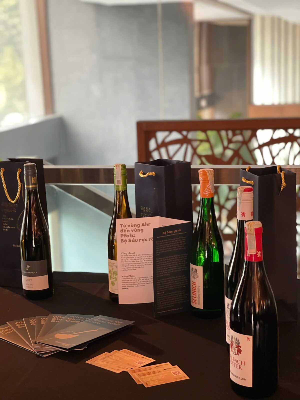 German wine bottles, gift bags and leaflets on a table by a window