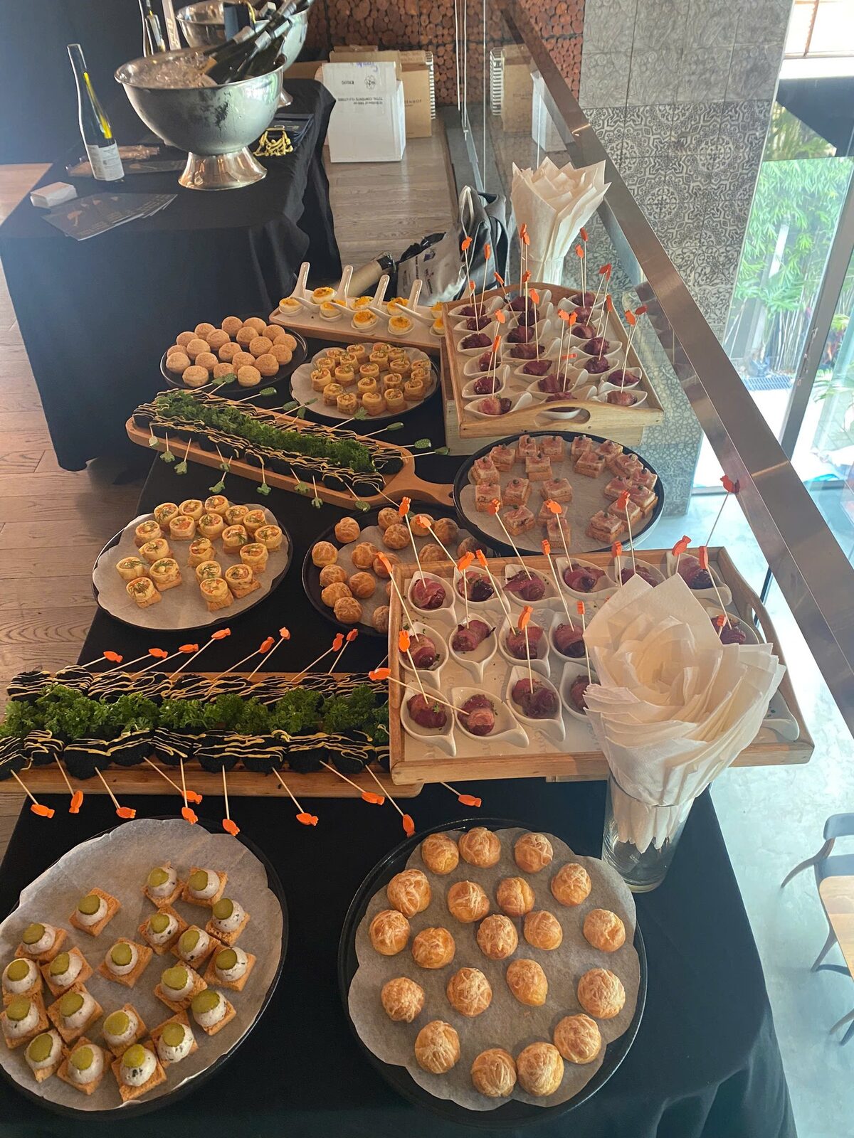 Buffet table with canapés, tartlets and small bites on wooden boards